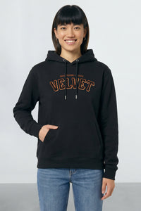 Person wearing a black hoodie with 'VELVET' text on a light background