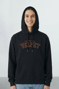 Person wearing a black hoodie with 'Velvet' text on a light background
