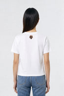 Person wearing a white t-shirt with a logo on the back against a plain background