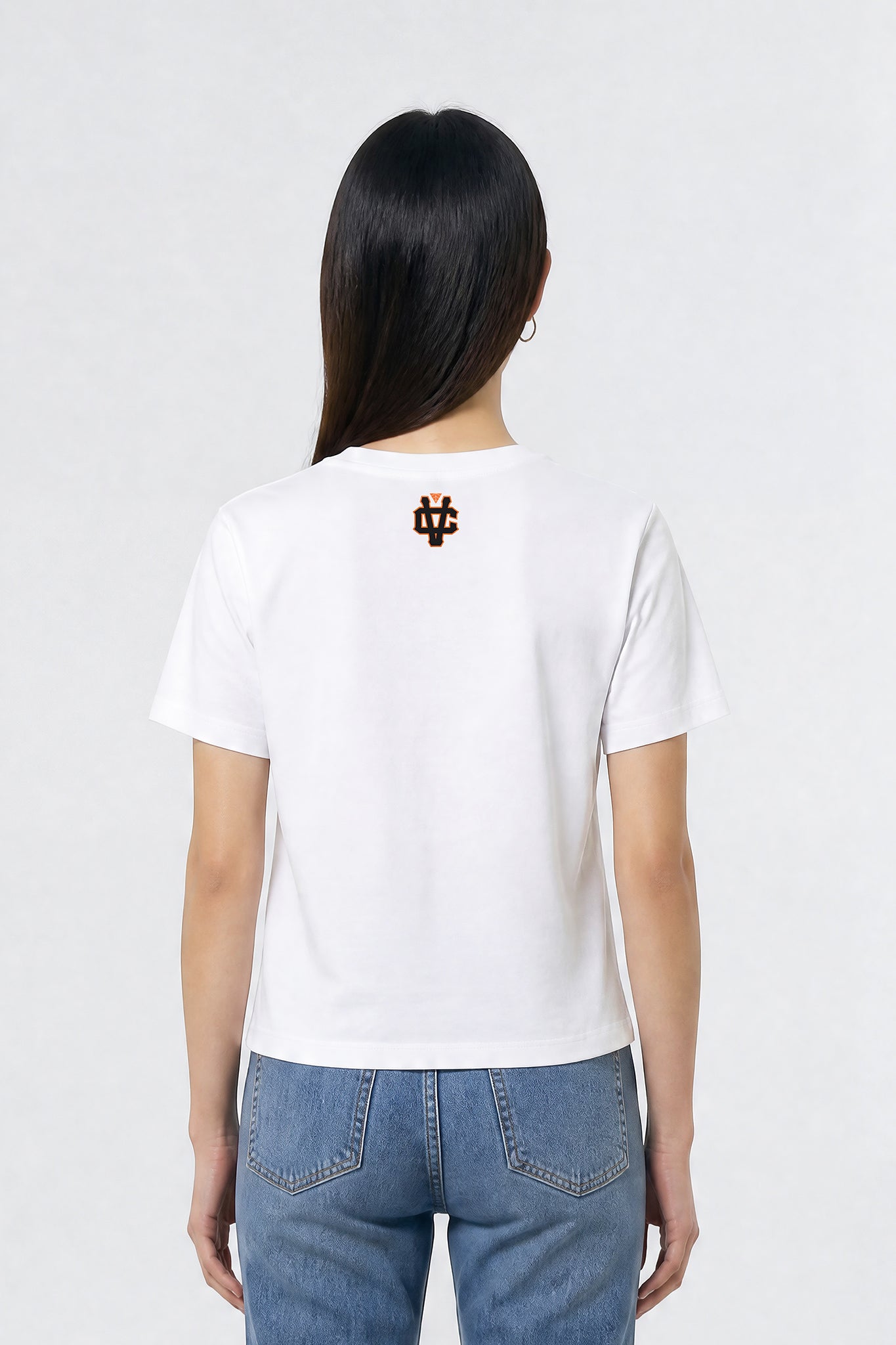 Person wearing a white t-shirt with a logo on the back against a plain background