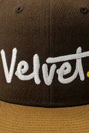Brown cap with 'Velvet' embroidered in white on a dark background
