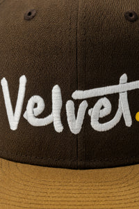 Brown cap with 'Velvet' embroidered in white on a dark background