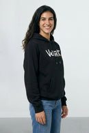 Person wearing a black hoodie with 'Velvet' logo on a light background