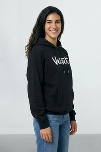 Person wearing a black hoodie with 'Velvet' logo on a light background
