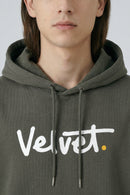 Person wearing a Khaki green hoodie with 'Velvet' logo