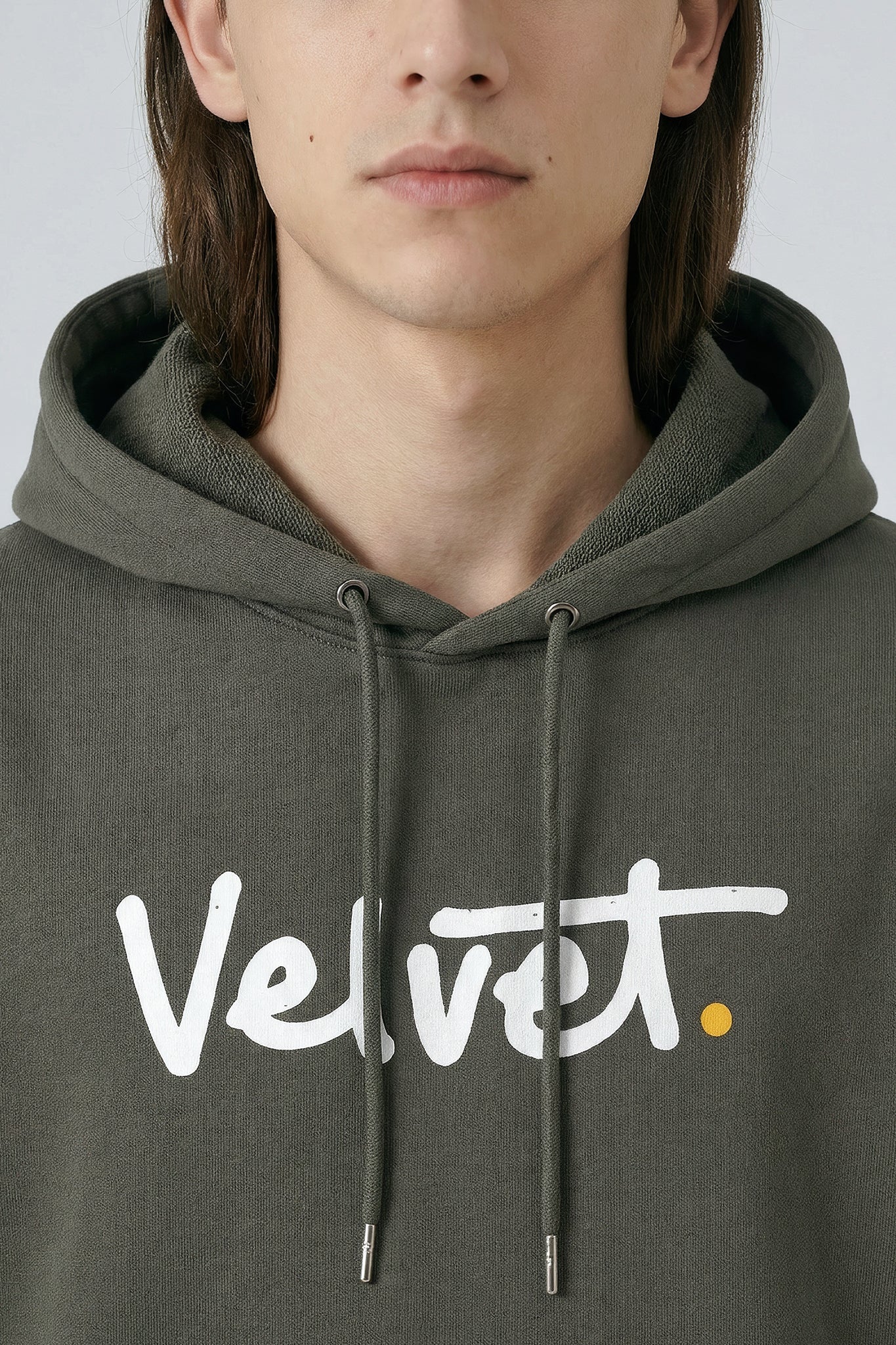 Person wearing a Khaki green hoodie with 'Velvet' logo
