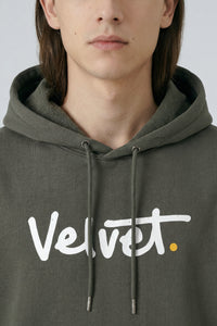 Person wearing a Khaki green hoodie with 'Velvet' logo