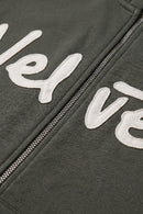 Khaki green jacket with white text and zipper detail
