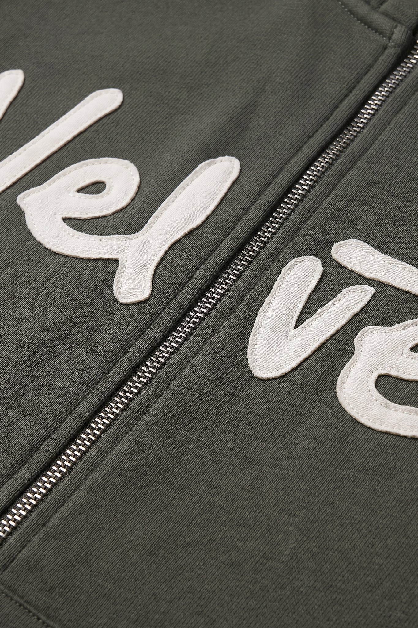 Khaki green jacket with white text and zipper detail