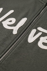 Khaki green jacket with white text and zipper detail