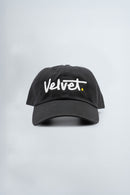 Black cap with 'Velvet.' text on a light gray background