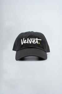 Black cap with 'Velvet.' text on a light gray background