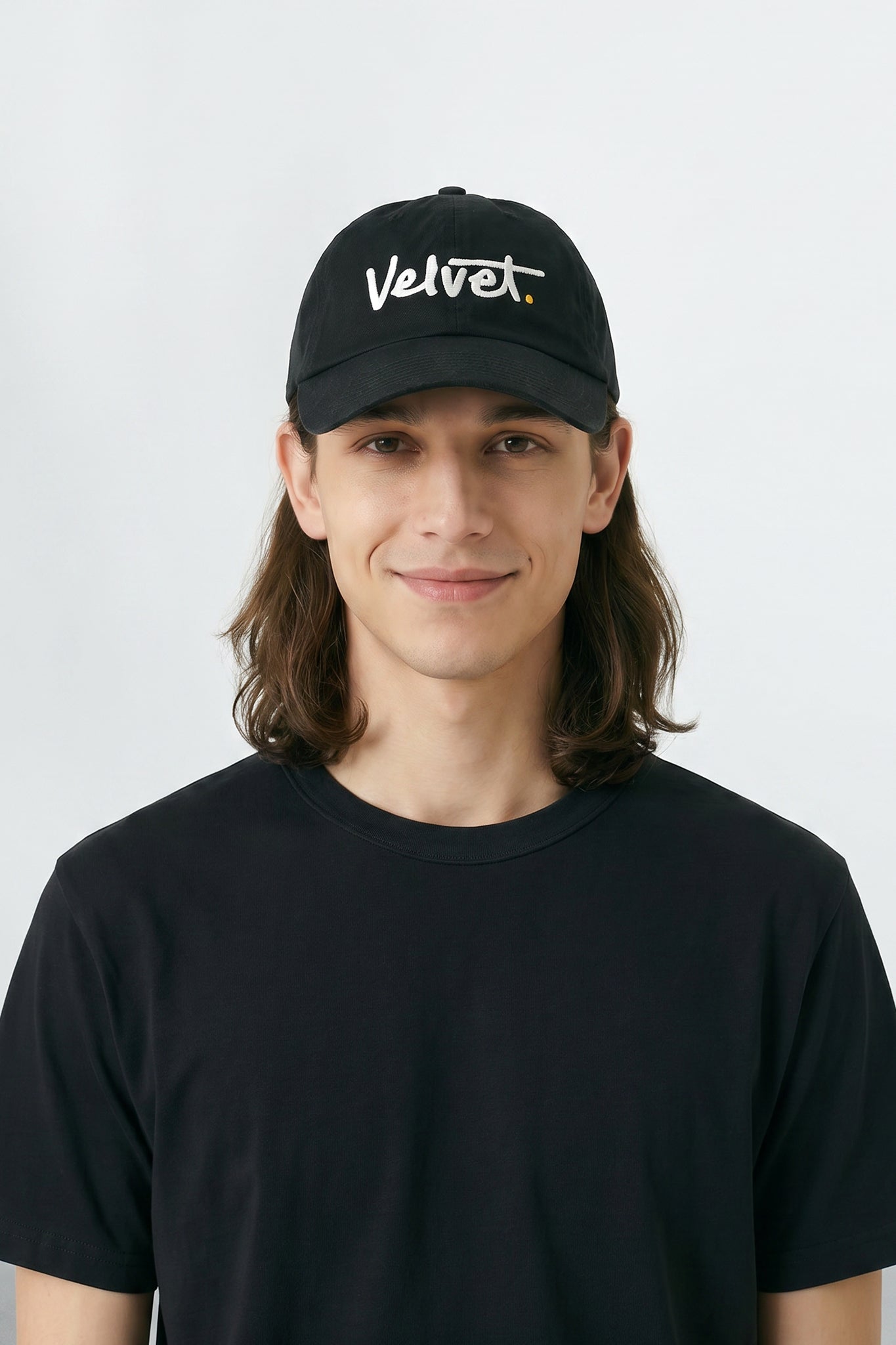 Person wearing a black cap with 'Velvet' text on a white background
