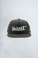 Black cap with 'Velvet' logo on a light background