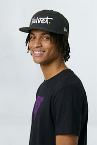 Man wearing a black cap with 'Velvet' logo 