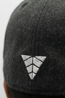 Black cap with a white embroidered logo on a light background