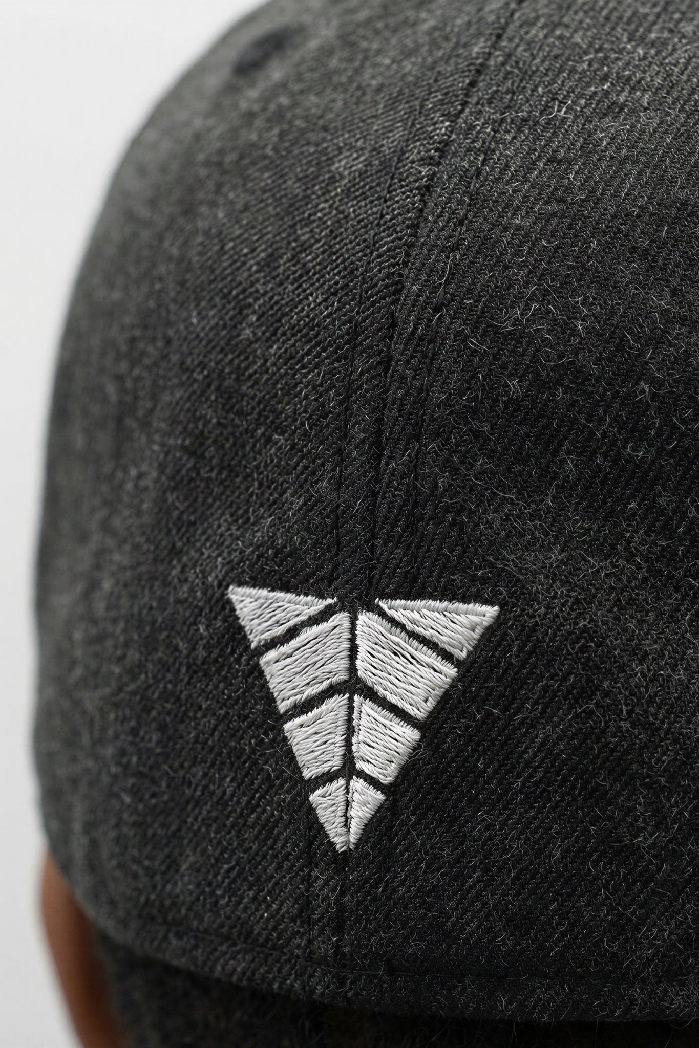 Black cap with a white embroidered logo on a light background