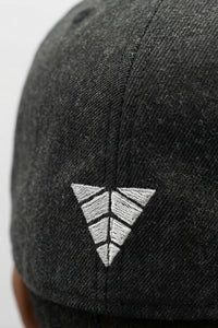 Black cap with a white embroidered logo on a light background