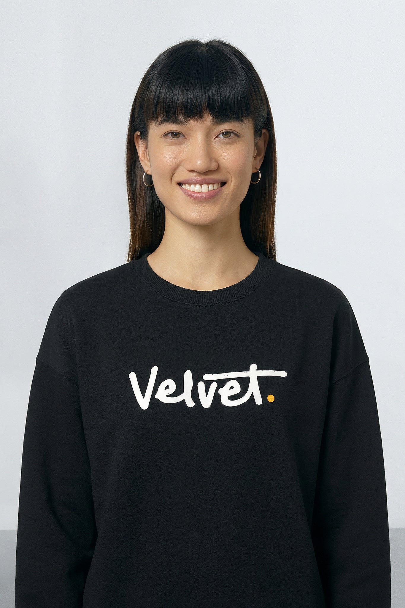 Person wearing a black sweatshirt with 'Velvet' text on a light background