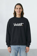 Person wearing a black sweatshirt with 'Velvet' text on a light background