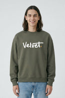 Person wearing a Khaki green sweatshirt with 'Velvet' text on a light background