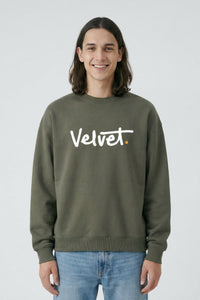 Person wearing a Khaki green sweatshirt with 'Velvet' text on a light background