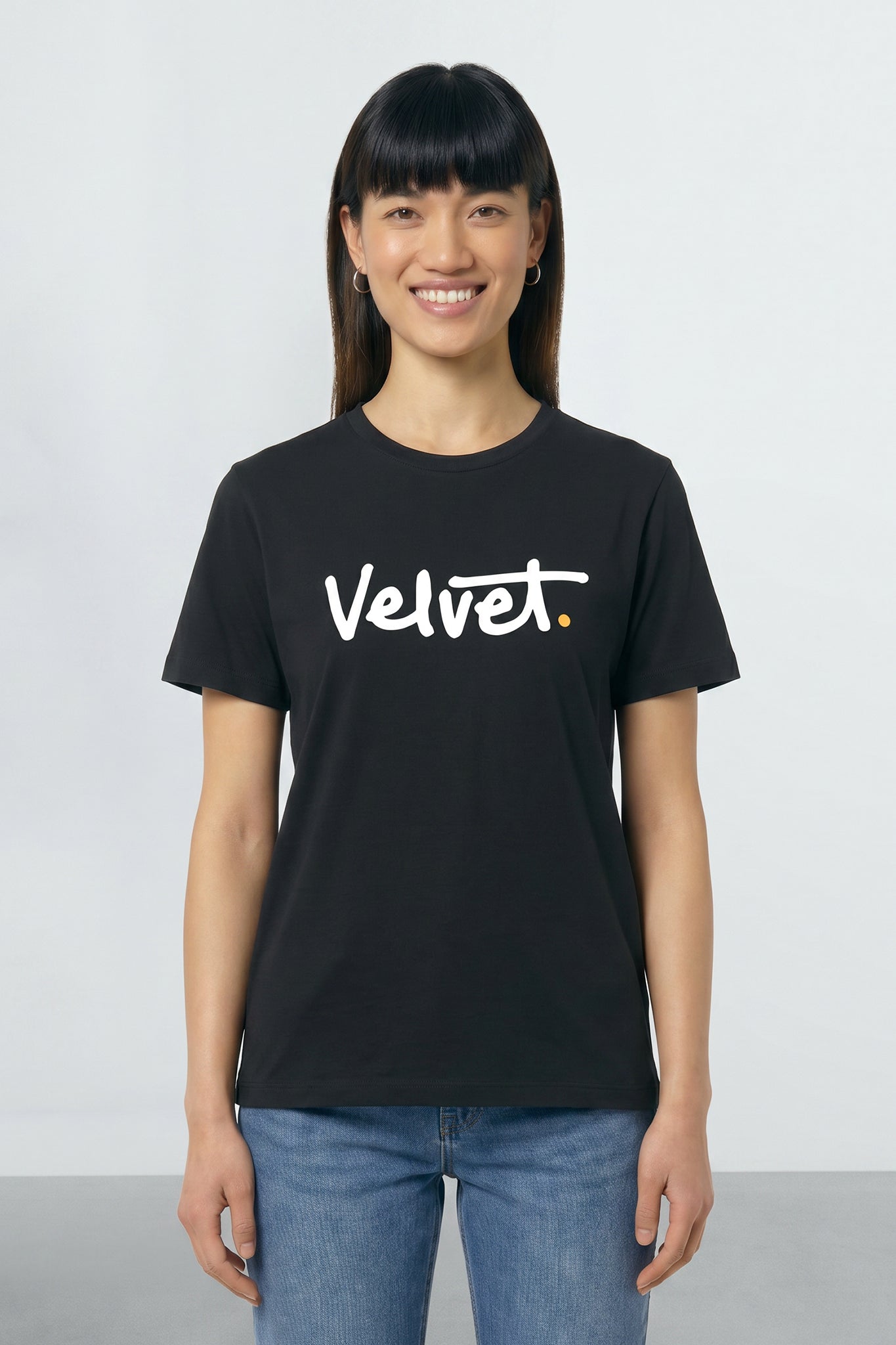 Person wearing a black t-shirt with 'Velvet' logo on a plain background