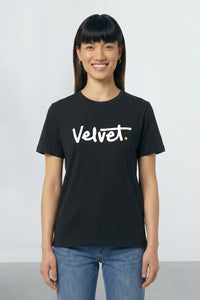 Person wearing a black t-shirt with 'Velvet' logo on a plain background