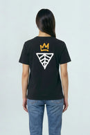 Person wearing a black t-shirt with a logo on the back against a light background