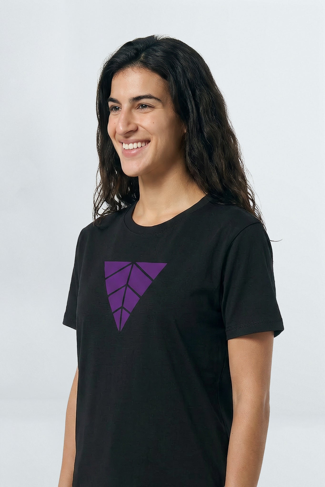 Person wearing a black t-shirt with a purple logo on a light  background