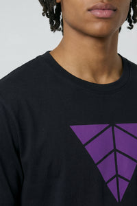 Person wearing a black t-Shirt with a purple geometric logo on a plain background