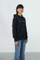 Person wearing a black hoodie with purple text on a light background