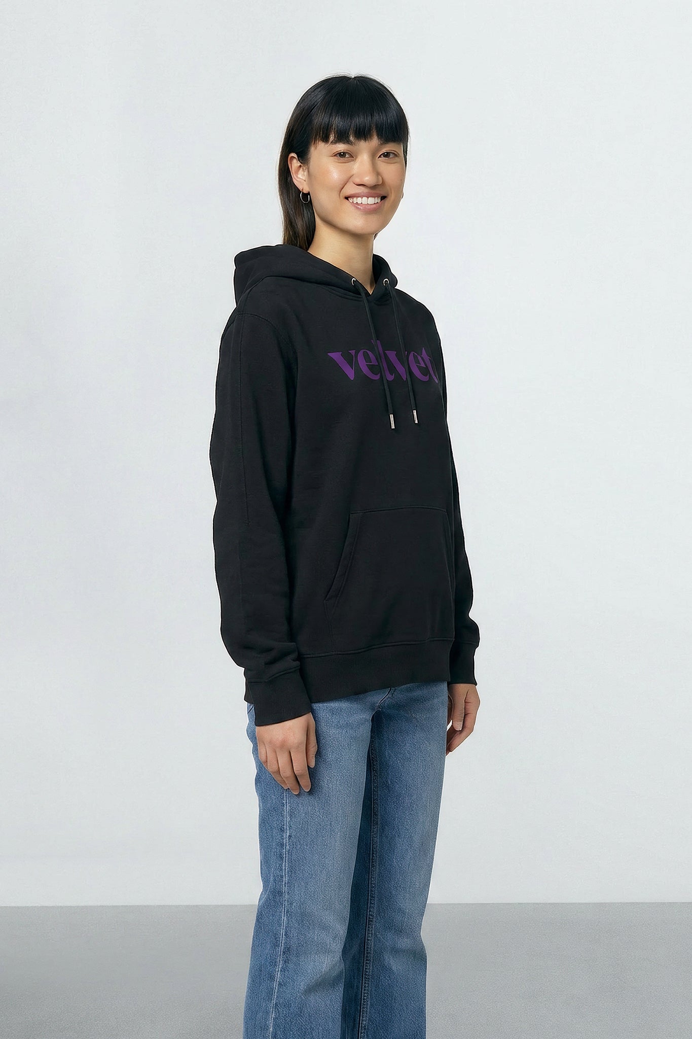 Person wearing a black hoodie with purple text on a light background