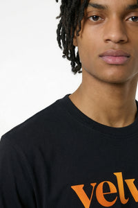 Person wearing a black shirt with Orange text on a light background