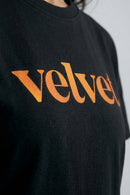 Black t-shirt with Orange  'velvet' text on a plain background