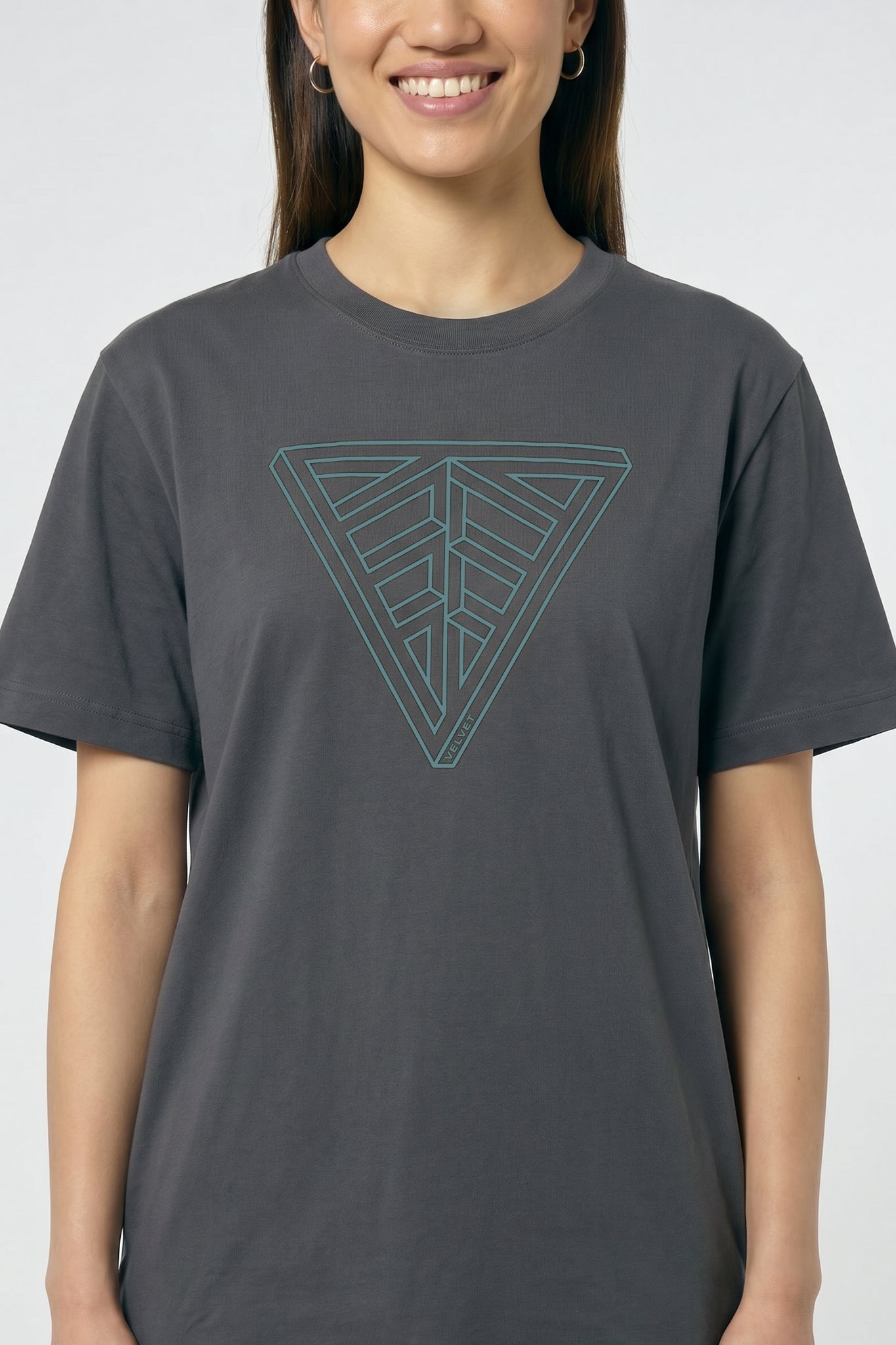 Person wearing a gray t-shirt with a geometric triangle design on a plain background