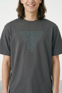 Person wearing a gray t-shirt with a geometric triangle design on a plain background