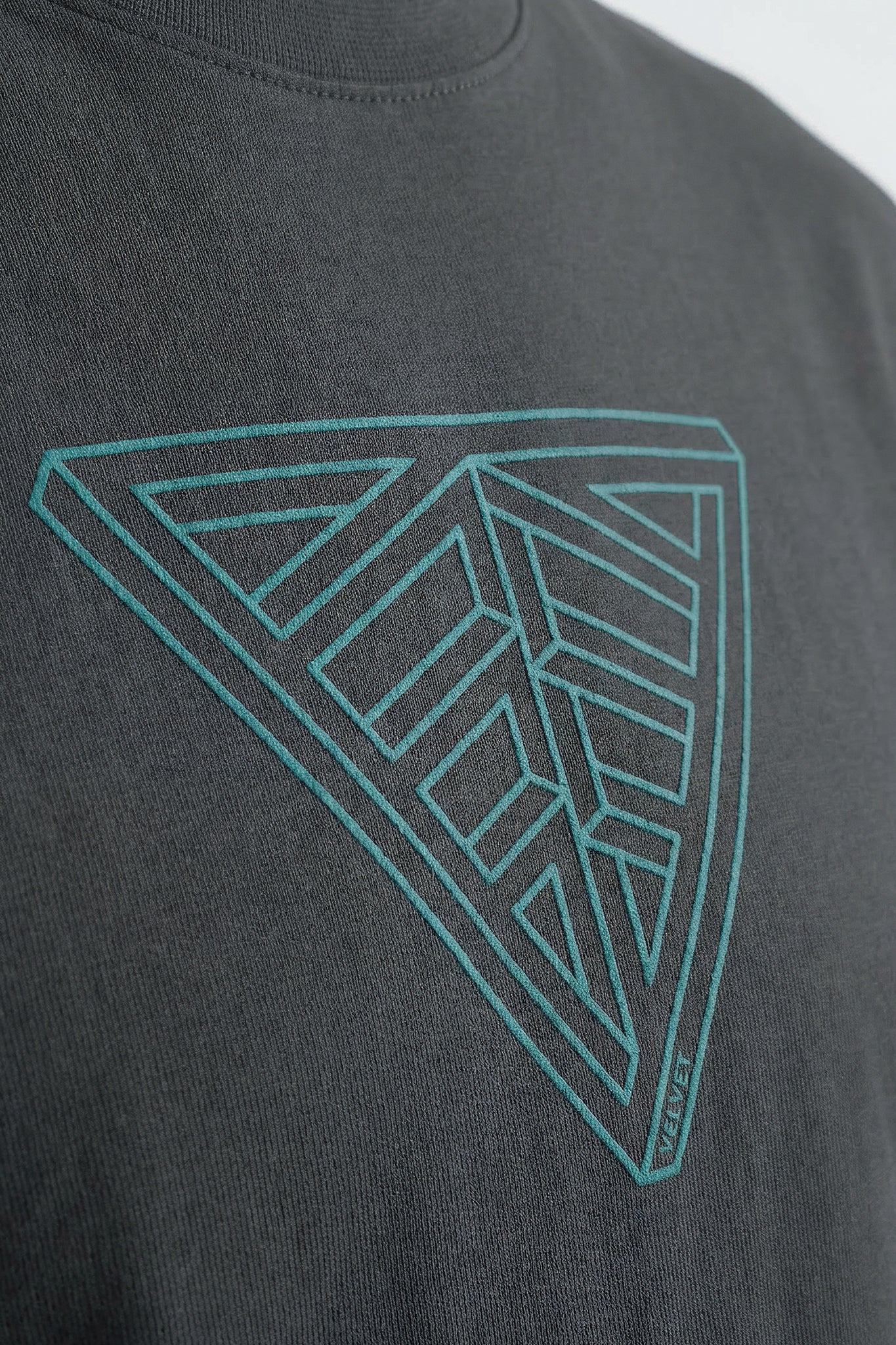 Gray t-shirt with a geometric triangle design in teal on a plain background