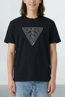 Person wearing a black t-shirt with a geometric design on a plain background