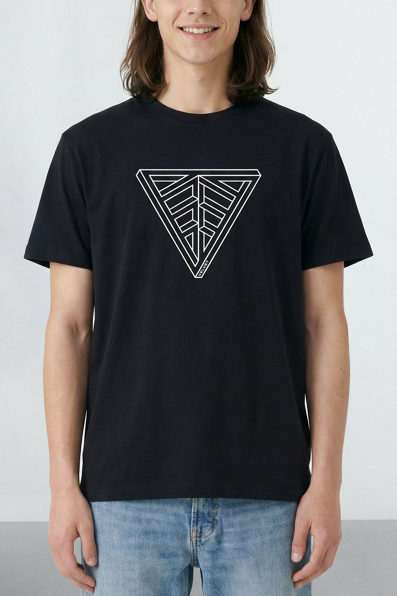 Person wearing a black t-shirt with a geometric design on a plain background