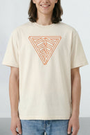 Person wearing a beige t-shirt with a geometric triangle design on a plain background
