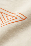 Close-up of a beige fabric with an orange geometric pattern