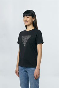 Person wearing a black t-shirt with a geometric design on a plain background