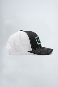 White and black cap with green logo on a light background
