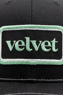Black cap with a green 'velvet' patch