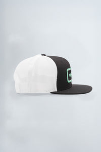 Two-tone black and white cap with a green logo on a light background
