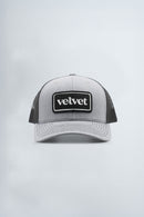 Gray and black cap with 'velvet' logo on a light gray background