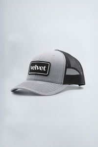 Gray and black cap with 'Velvet' logo on a light gray background