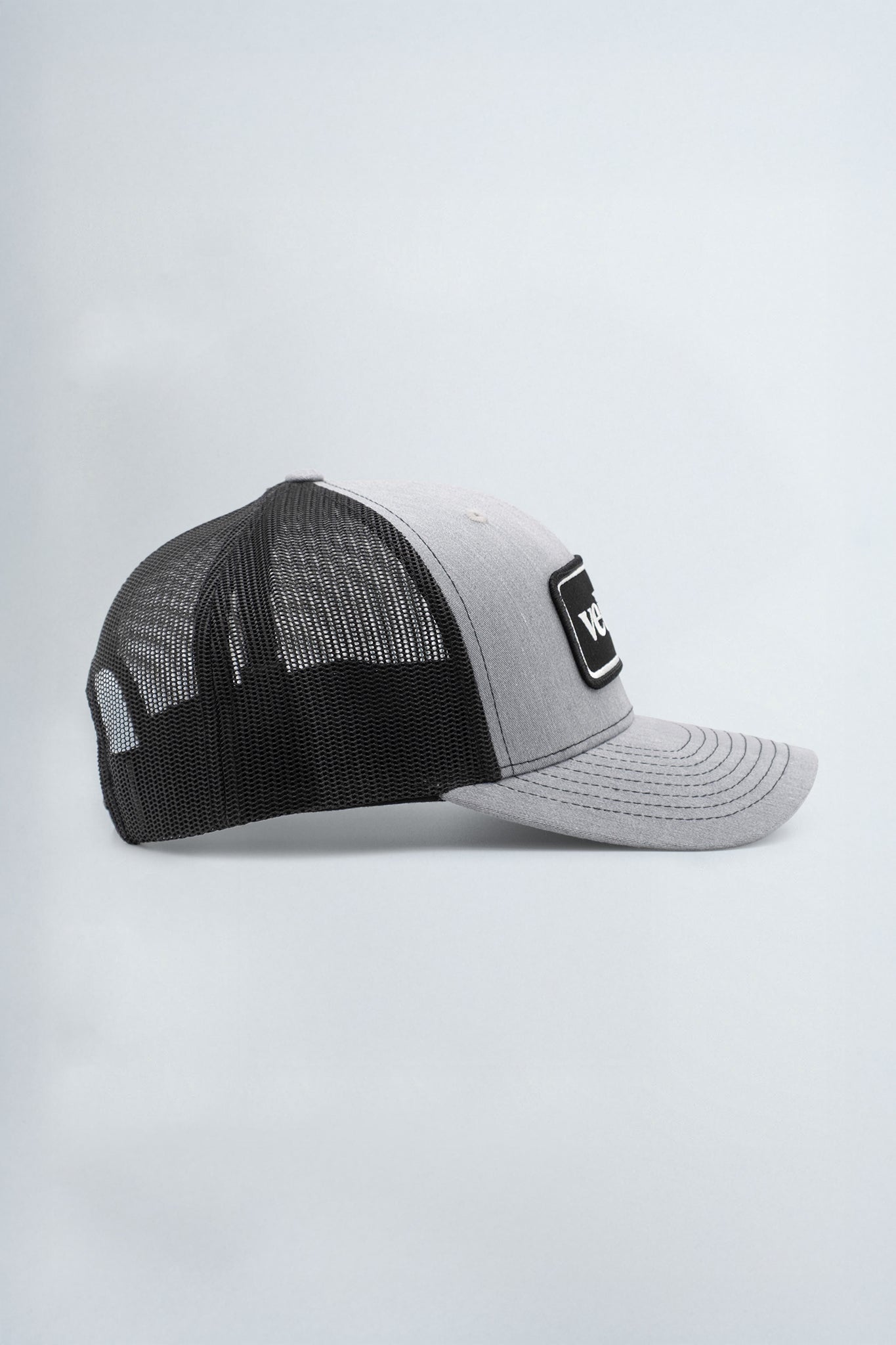 Black and gray trucker cap with a logo on a light gray background