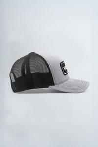 Black and gray trucker cap with a logo on a light gray background